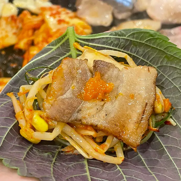 신선한 깻잎 위에 푸짐하게 올라간 고기와 채소