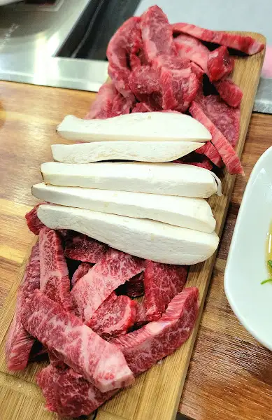 신선한 소고기와 버섯이 담긴 목재 도마