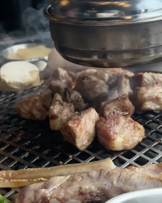 숯불 위에서 먹음직스럽게 구워지고 있는 흑돼지 덩어리들