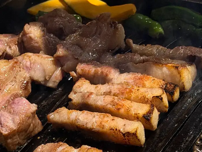 마장동김씨 명촌맛집점에서 숯불 위에 구워지고 있는 삼겹살과 목살의 클로즈업 샷