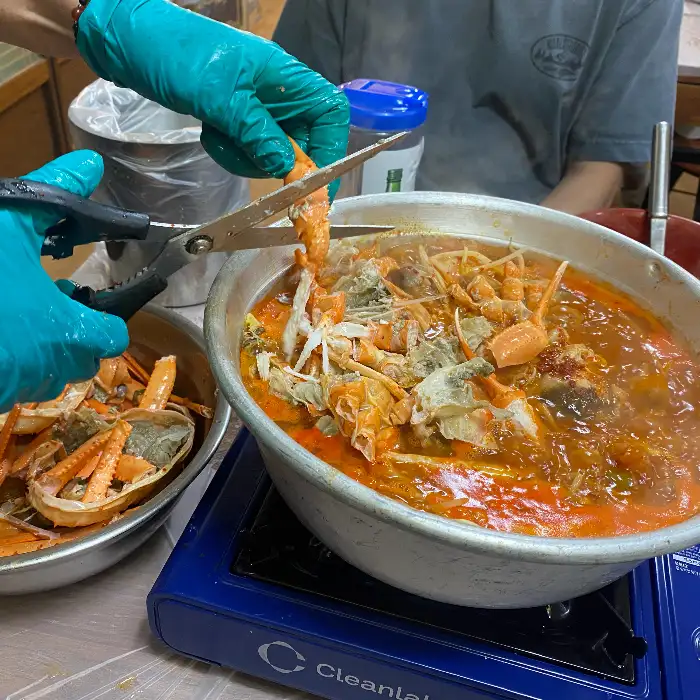 가위로 정성스럽게 홍게 살을 발라주는 모습