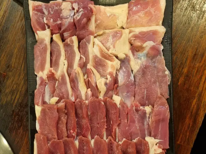 다양한 부위의 신선한 오리고기가 접시에 먹음직스럽게 담겨 있습니다.