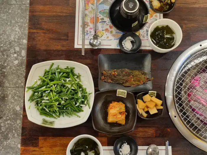테이블 위에 차려진 신선한 오리고기 구이와 다양한 밑반찬