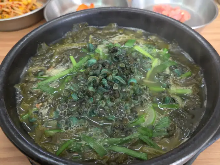 다슬기 해장국에 다슬기와 야채가 풍성하게 담긴 모습