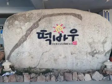 떡바우 횟집 입구의 상호명이 새겨진 큰 바위 조형물