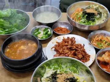 다양한 닭발 요리와 비빔밥, 쌈 채소가 차려진 푸짐한 상차림