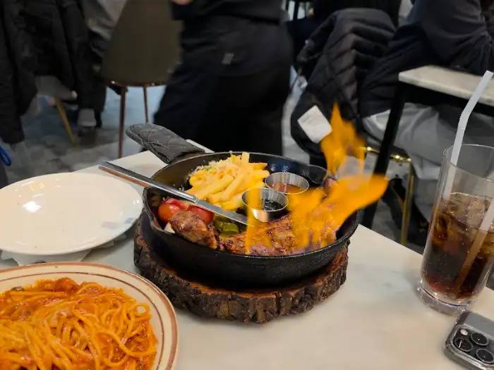 동백식탁 통삼겹스테이크에 불이 붙어 활활 타오르는 모습