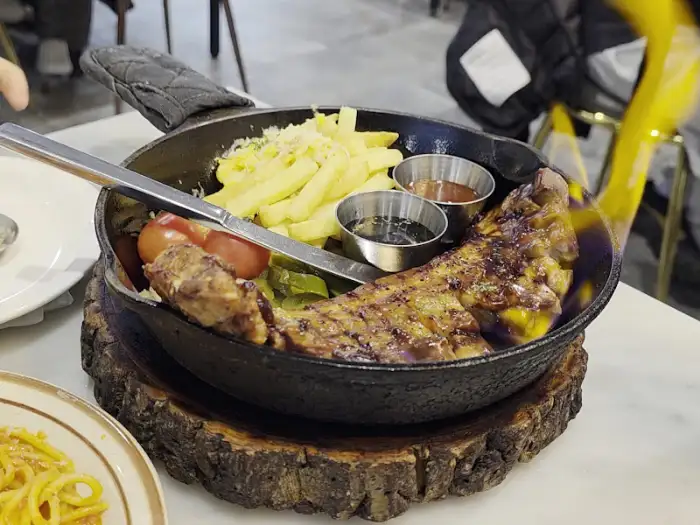 테이블에서 불쇼를 하고 있는 동백식탁 통삼겹스테이크