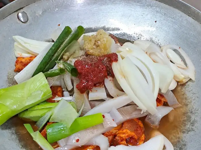 끓고 있는 냄비 안에 푸짐하게 담긴 오삼불고기 재료와 양념