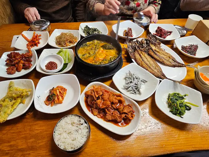 동이식당의 메인 요리와 다양한 찬들, 풍성한 식사를 보여줍니다.