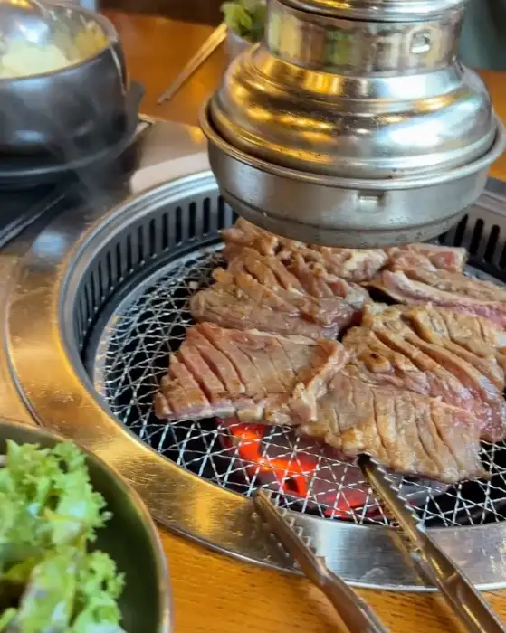 숯불 위에서 익어가는 도톰한 삼겹살 부위