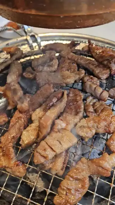 명륜진사갈비 김해장유점의 여러 부위의 고기가 숯불 위에서 구워지고 있는 모습