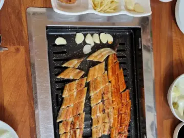 기찬민물장어에서 갓 구워낸 두툼한 장어구이와 곁들임 찬