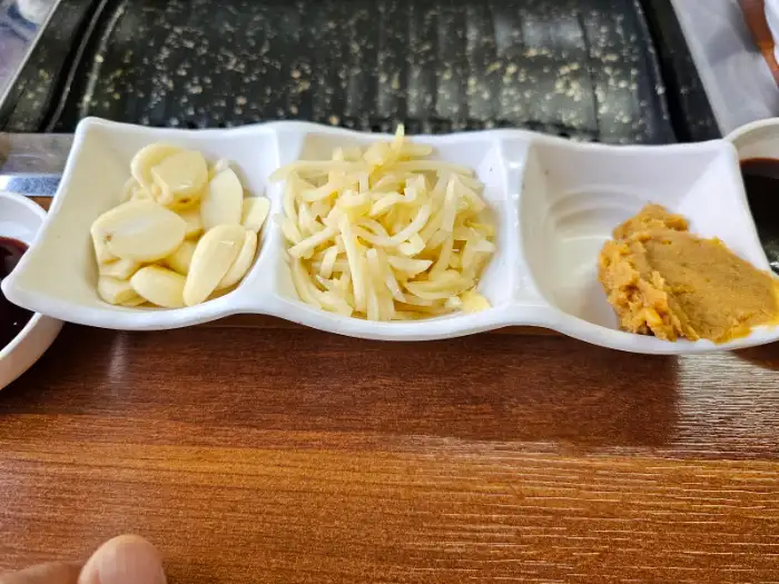 기찬민물장어의 곁들임 찬으로 제공되는 마늘, 양파, 쌈장