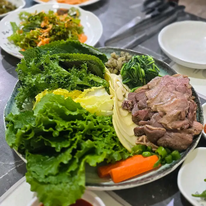 신선한 채소와 먹음직스러운 오리수육이 풍성하게 담긴 접시