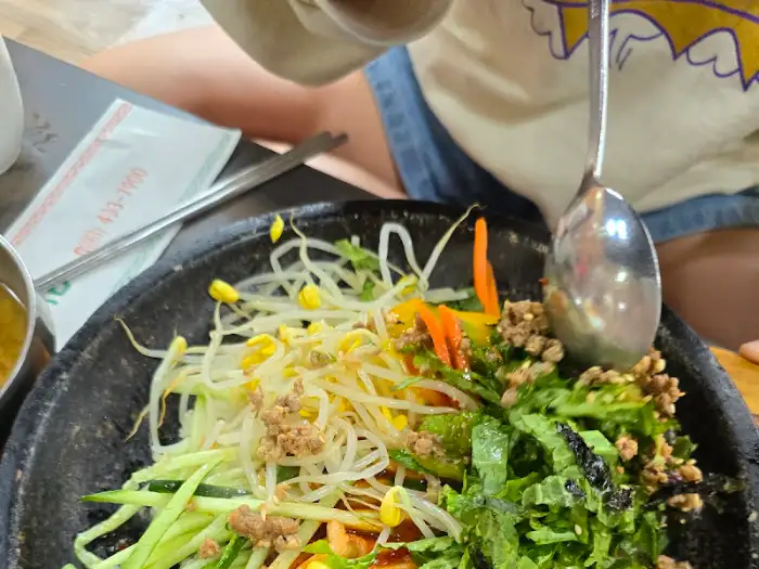 강진 금두꺼비 돌솥 비빔밥, 뜨거운 돌판 위 신선한 채소와 밥이 조화로운 모습