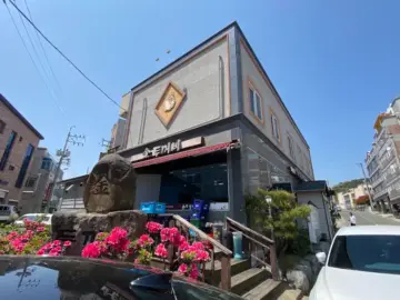 강진 금두꺼비 외관 전경, 붉은 꽃과 함께 자리한 풍경