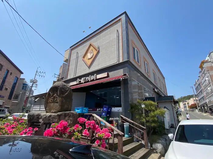 강진 금두꺼비 외관 전경, 붉은 꽃과 함께 자리한 풍경