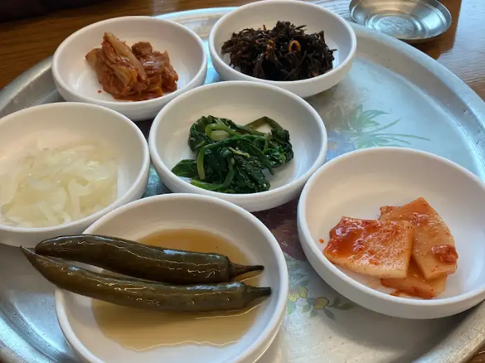 다양한 종류의 밑반찬이 담긴 6개의 작은 접시