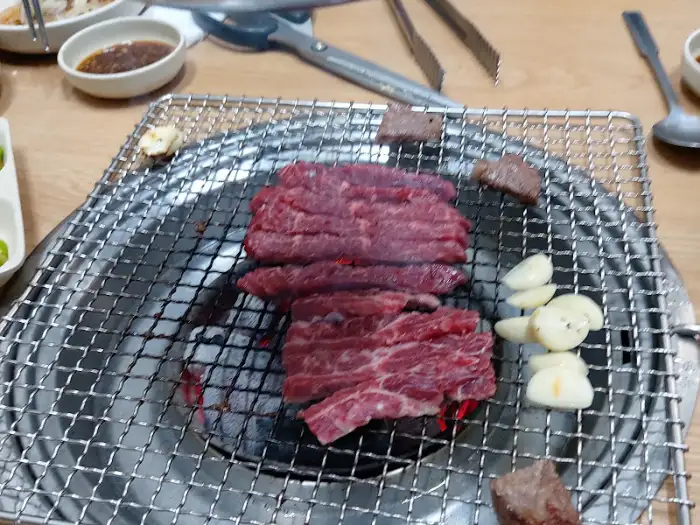 숯불 위에서 구워지고 있는 두툼한 한우 등심 부위