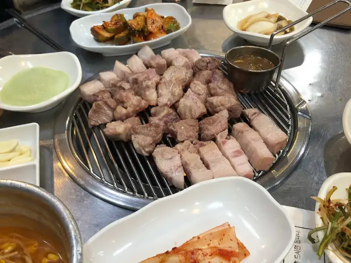 그릴 위에 올려진 먹음직스러운 돼지고기와 곁들임 소스