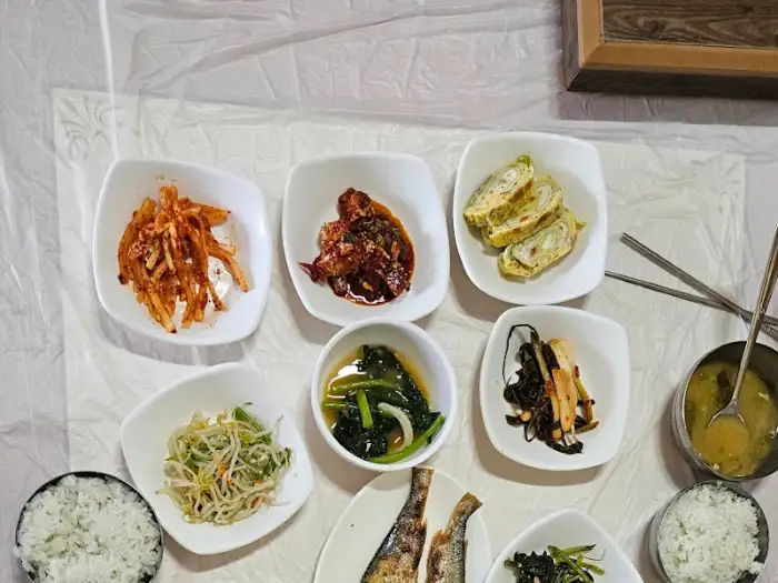 다양한 나물 반찬과 생선구이, 계란말이가 차려진 백반 한 상