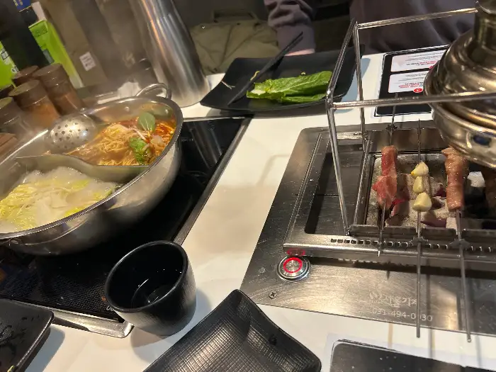 테이블 위 훠궈 냄비와 양꼬치를 굽는 불판
