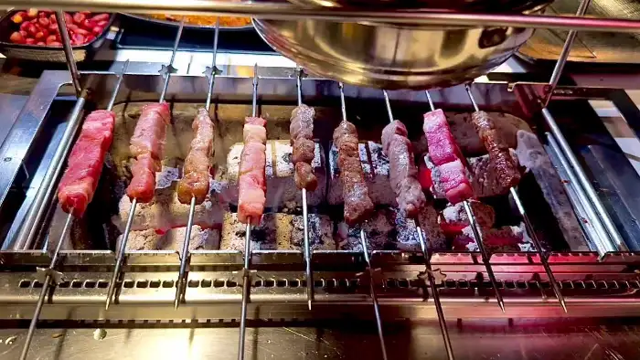 숯불 위에서 구워지는 여러 종류의 꼬치 요리