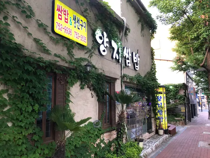 순천 양지 생선구이 간판과 입구 모습, 노란색 간판에 '밥집 생선구이'라고 적혀 있고, '양지'라는 한글 간판도 보인다.