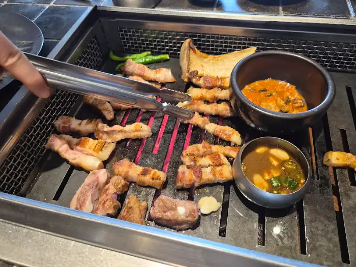 궤네깃도 중문흑돼지 제주본점에서 직원분이 흑돼지 오겹살을 구워주는 모습