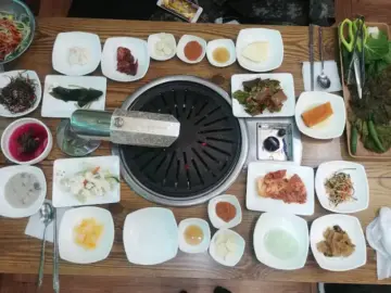 부안 수라청: 푸짐한 밑반찬과 두툼한 고기의 조화 부안 수라청에서 주문한 삼겹살, 목살과 다채로운 밑반찬이 차려진 상차림
