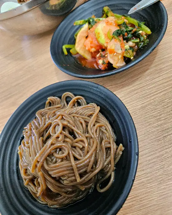 도자기 접시에 담긴 막국수와 곁들임 반찬