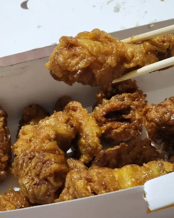 젓가락으로 집어 올린 치킨 조각