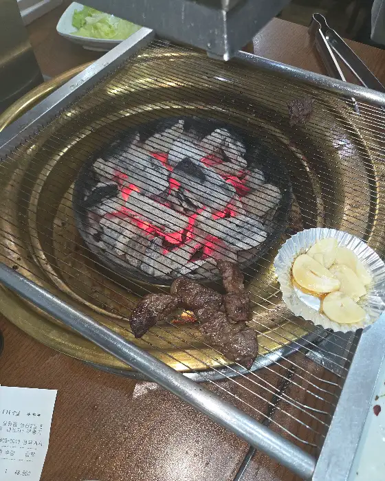 숯불 위에서 익어가는 고기 조각들