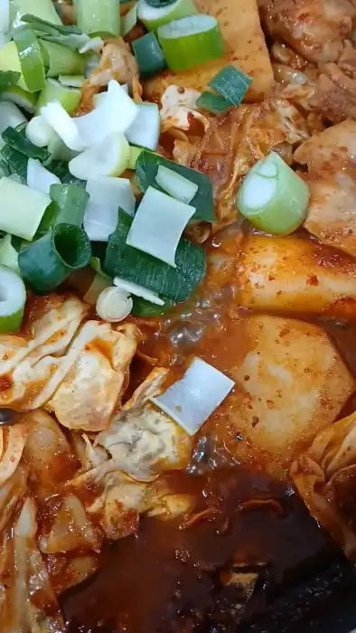 닭갈비 위에 올린 파와 떡