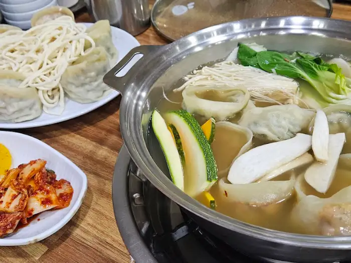 테이블 위에 차려진 전골과 곁들임 음식들