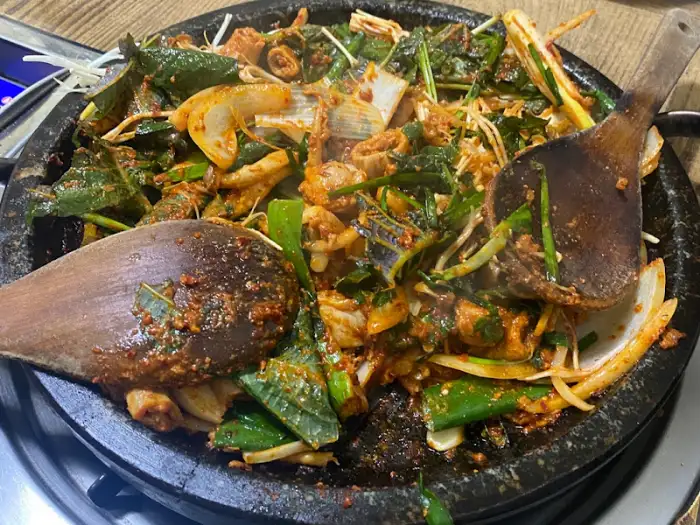 돌판 위에 푸짐하게 담긴 매콤한 구이