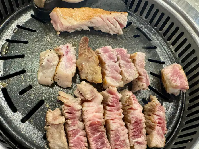 잘 익은 고기를 집게로 집고 있는 모습