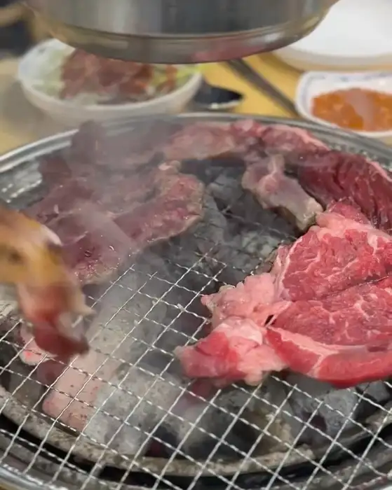 다양한 부위의 소고기가 숯불 위에서 구워지고 있는 모습