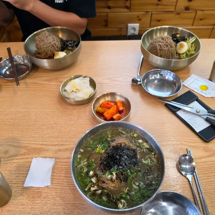 테이블에 놓인 두 그릇의 막국수와 곁들임 메뉴들