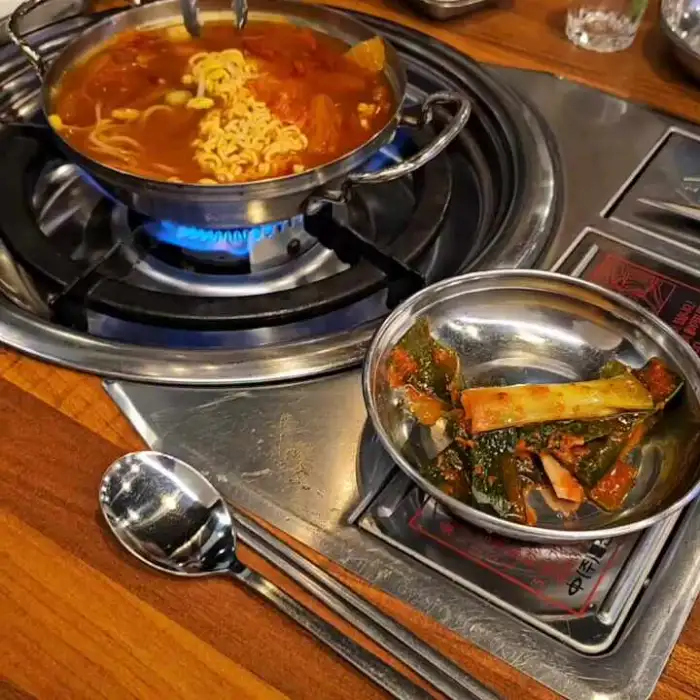 테이블 위 지글지글 구워지는 곱창과 함께 나온 라면 전골