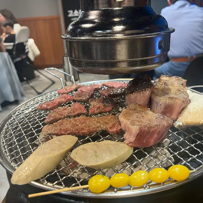잘 구워진 고기와 곁들임 메뉴들이 놓여있는 불판
