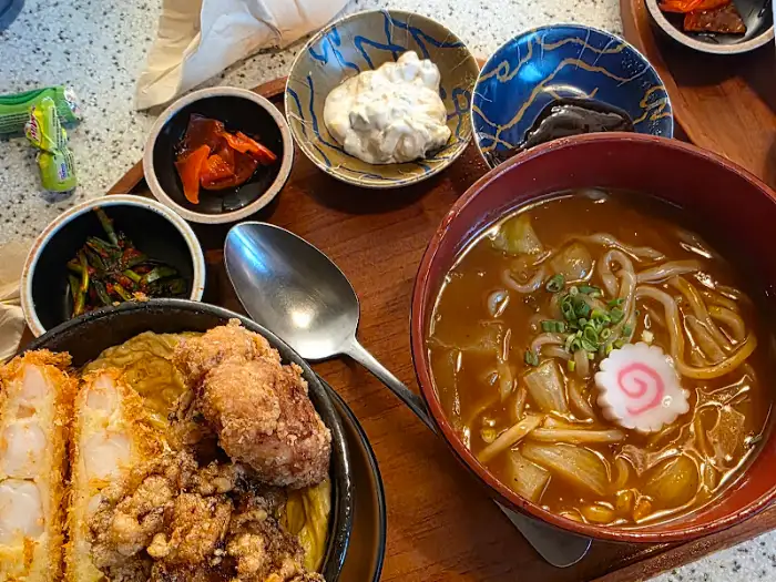 카레 우동과 덮밥, 반찬이 함께 차려진 모습