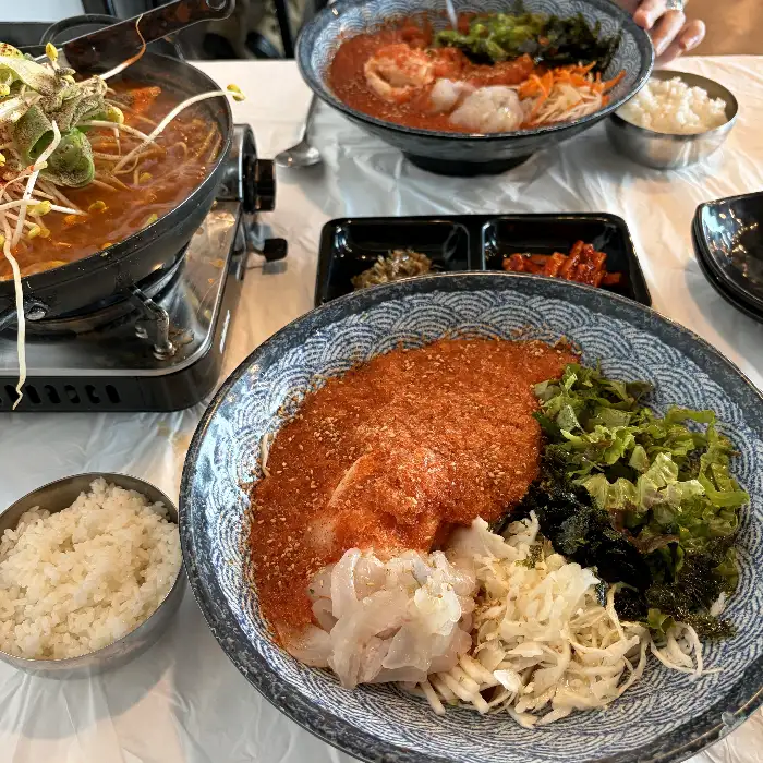 테이블에 차려진 푸짐한 한 상, 물회와 매운탕, 밥이 조화롭게 배치