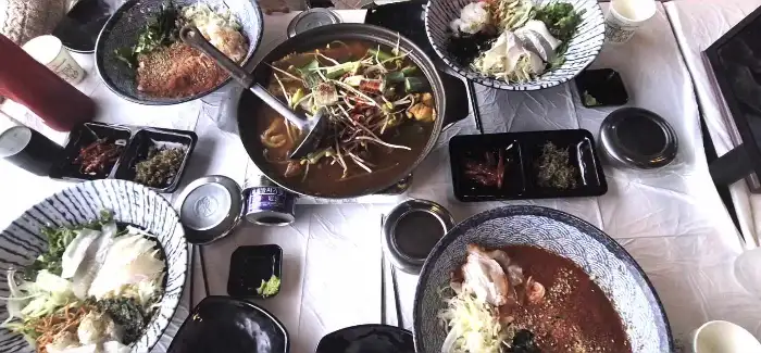 여러 개의 물회 그릇과 매운탕 냄비가 놓인 테이블 전경