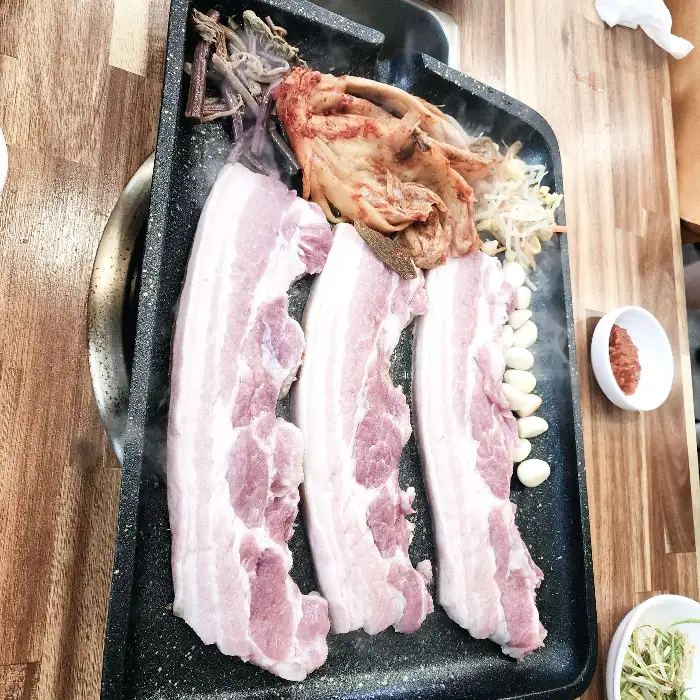 팬 위에서 익어가는 흑돼지와 묵은지, 콩나물