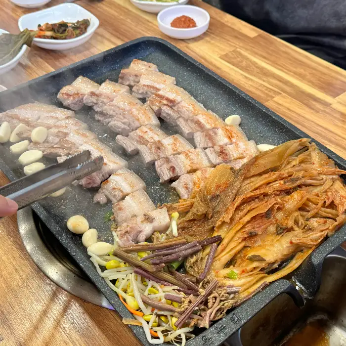 지글지글 볶아지는 흑돼지 주물럭과 곁들임 음식들