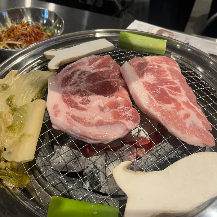 숯불 위에서 익어가는 목살과 항정살