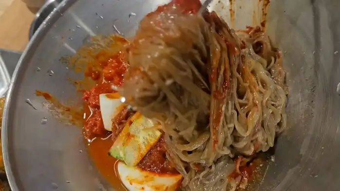회냉면의 면발을 들어 올리는 모습