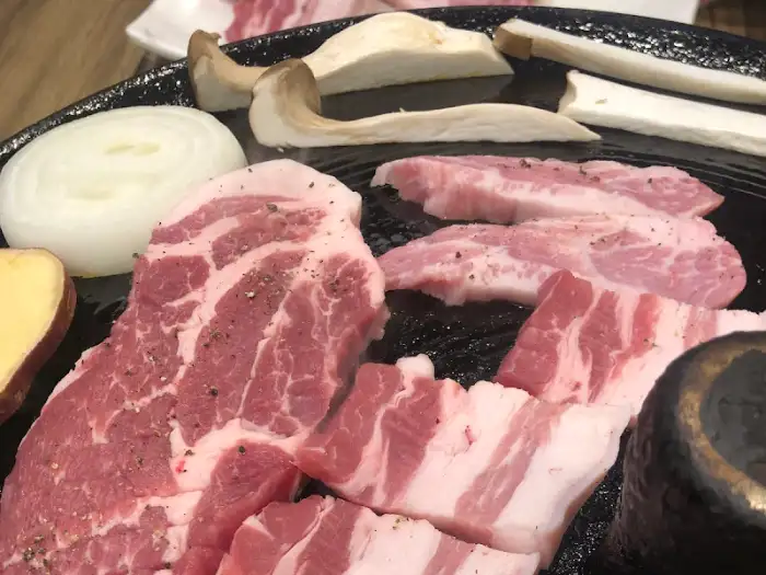 신선한 흑돼지 삼겹살 덩어리와 곁들임 재료